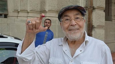 حسن يوسف يشير بعلامة CC أمام لجنته الانتخابية