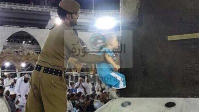 صورة رجل أمن يرفع طفلاً لتقبيل الكعبة تثير الإعجاب