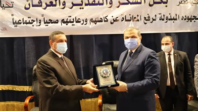 سعفان ومحافظ البحيرة يتبادلان الدروع في حفل تسليم بوالص التأمين 