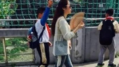 الحكومة الصينية تتدخل رسميا بسبب صورة لطالب يمسك بمظلة لمعلمته