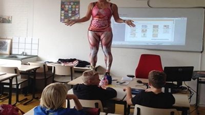 بالصور .. معلمة هولندية ترتدي ملابس غريبة تظهر جسم الانسان لشرح  