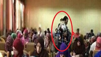 استاذ بجامعة القاهرة يحمل رضيعة لتمكين والدتها من اداء الامتحان